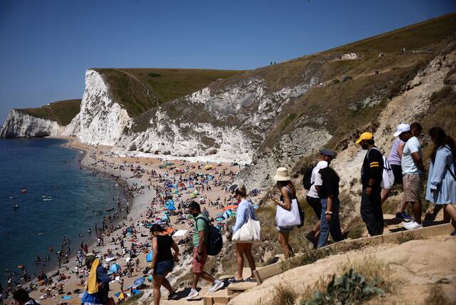 当地时间16日，英国遭遇高温热浪，民众涌入多塞特郡海滩避暑降温。图丨ICphoto