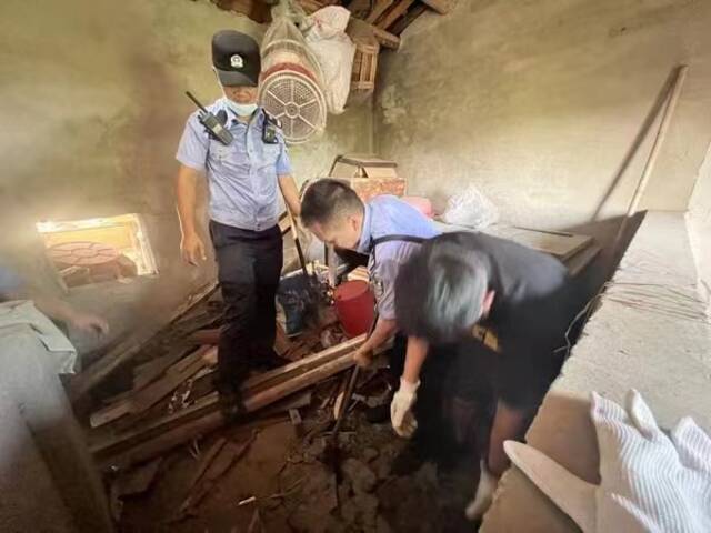 7月13日，民警在犯罪嫌疑人老家的猪圈里将藏有赃款的保险箱挖出。（受访对象供图）