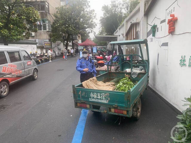 贩卖艾草占用非机动车泊位阻塞道路的现场照片