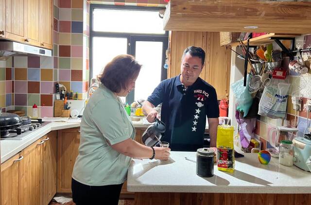 克里斯蒂安·阿卡尔在位于辽宁省大连市甘井子区的家中和妻子一起准备阿根廷下午茶。新华社记者赵洪南摄
