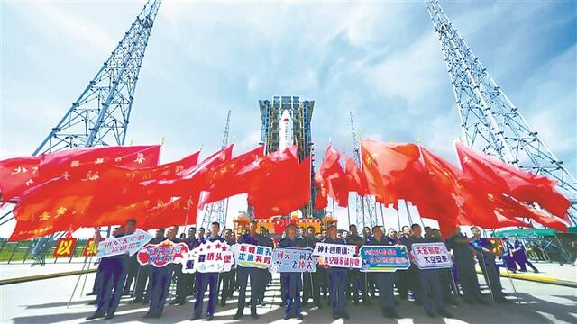 7月18日，海南文昌，问天实验舱与火箭组合体转运现场，工程师在发射台前合影。(图片来源：视觉中国)