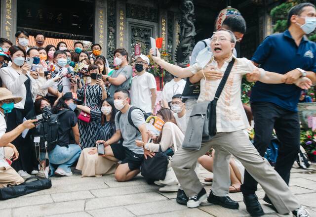 陈时中20日前往龙山寺参拜，有民众（右）大喊“陈时中可以保障台北市民吗？”随即被人架离现场。图自台媒