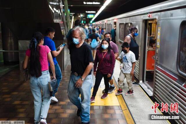 当地时间7月13日，美国洛杉矶民众佩戴口罩乘坐地铁。