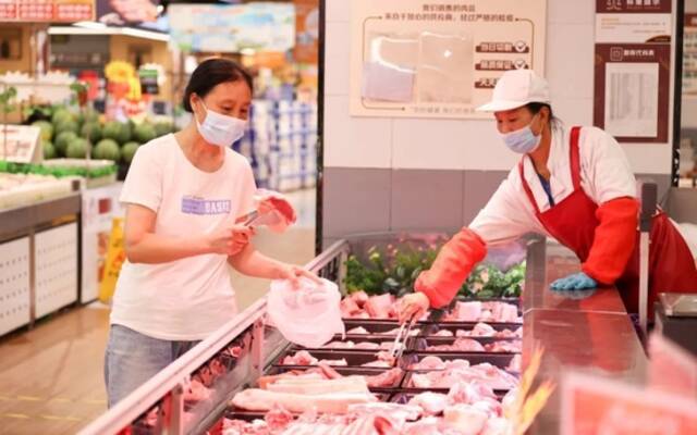 ▲7月9日，江苏连云港，消费者在一家超市内选购猪肉。图/IC photo