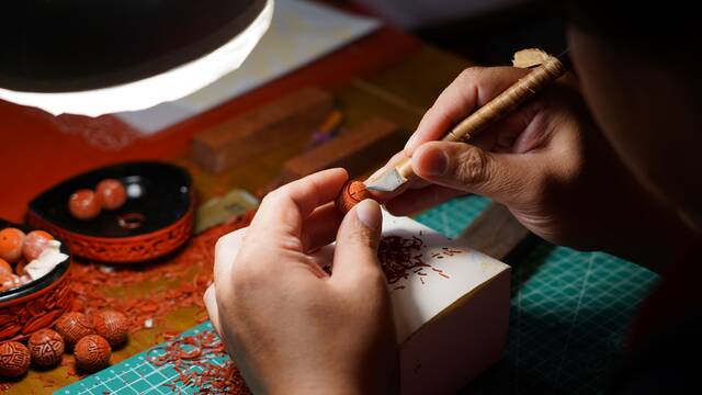 7月19日，刘楠正在雕刻中国传统的团寿纹。新京报记者戚厚磊摄