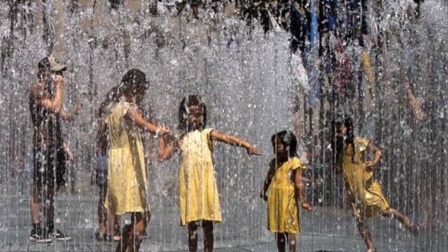 7月23日，美国纽约，孩子们在喷泉旁玩水降温