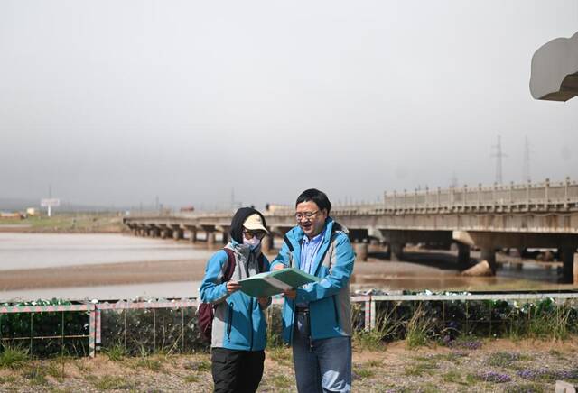 在长江源地区，焦弘睿（左）与导师在查看江源地区的资料。新华社记者张龙摄