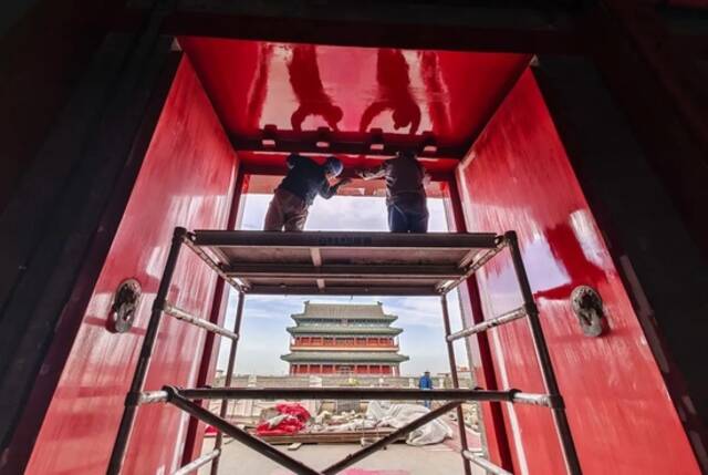 2021年10月14日，正阳门箭楼，工人在按照古法修缮大门。