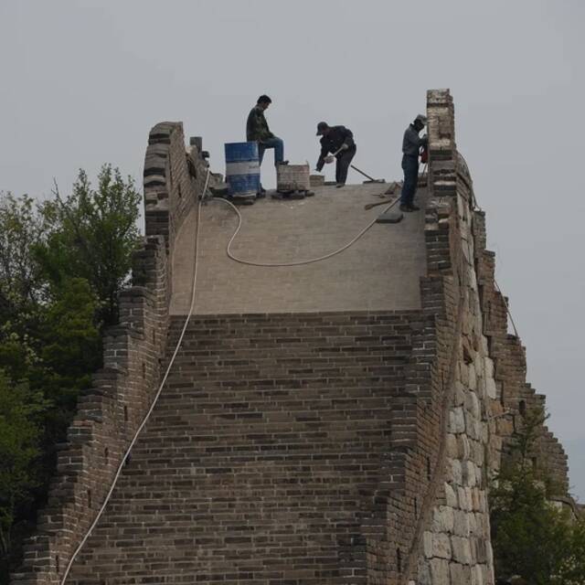 2017年5月3日，箭扣长城修缮工地，工人们在山顶的长城上施工。