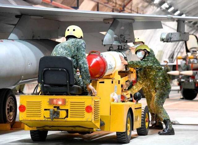 台军士兵在佳山洞库内替F-16战机进行空射型鱼叉导弹挂载。图片来源：台湾“中时新闻网”