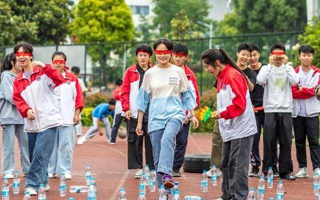 ▲2021年5月，贵州黔西市第一中学高三学生参加“勇闯地雷阵”游戏，集体释压。图/新华社