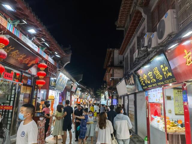 游人们在济南特色老街芙蓉街品尝各种特色美食，感受城市夜晚“烟火气”。（新华社记者王志摄）