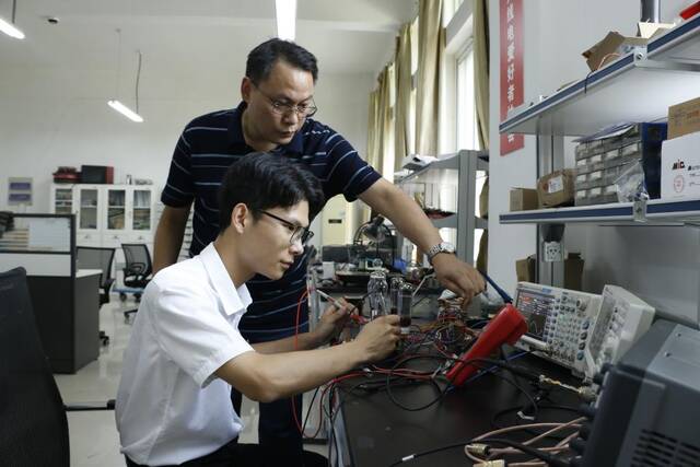 刘拥军老师在指导孟荣恩进行实践训练。（刘振坤摄）