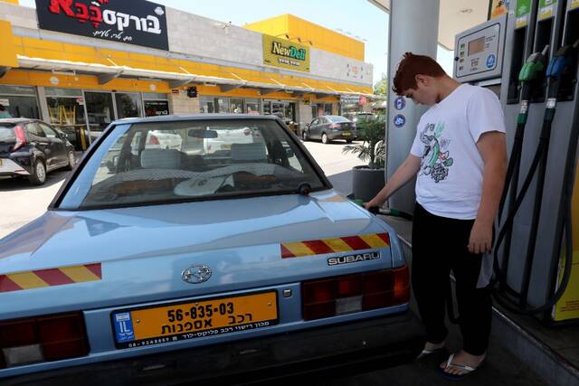 6月30日，一名男子在以色列莫迪因一座加油站为汽车加油。新华社发（吉尔·科恩·马根摄）