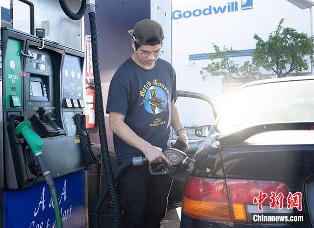 资料图：当地时间6月11日，一名车主在美国加州圣马特奥县一家加油站为车辆加油。美国汽车协会的数据显示，当天全美平均汽油价格升至每加仑5.004美元（1加仑约为3.7升）。这是美国历史上平均汽油价格首次突破5美元，而一年前这一数据仅为3.077美元。中新社记者刘关关摄