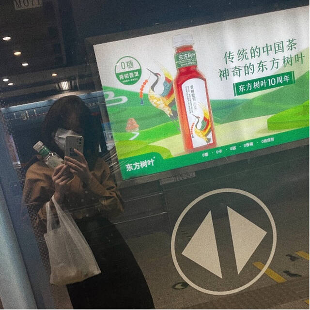 靓靓在地铁里与东方树叶广告合影图源：被访者提供