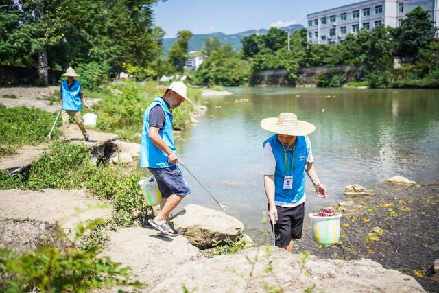 仁怀市五马镇生态环境保护协会会员在五马河岸边捡拾垃圾。新华社记者陶亮摄