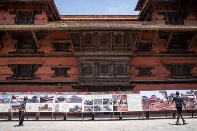 ▲2022年7月15日，在尼泊尔加德满都，行人经过修复后的九层神庙建筑群。中国援助加德满都杜巴广场九层神庙建筑群修复项目文物本体维修，于近日圆满完成。图/新华社