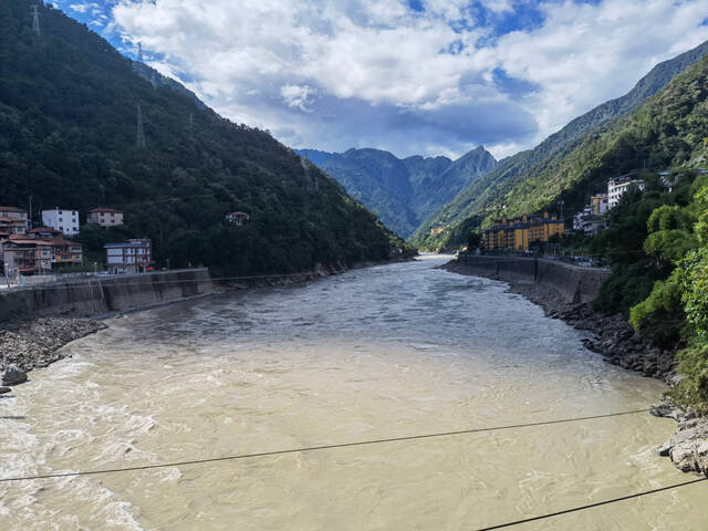 从马吉桥上看怒江江景，远处黄色的楼房是当地政府为村民们在山脚下修的新房。新京报记者李照摄