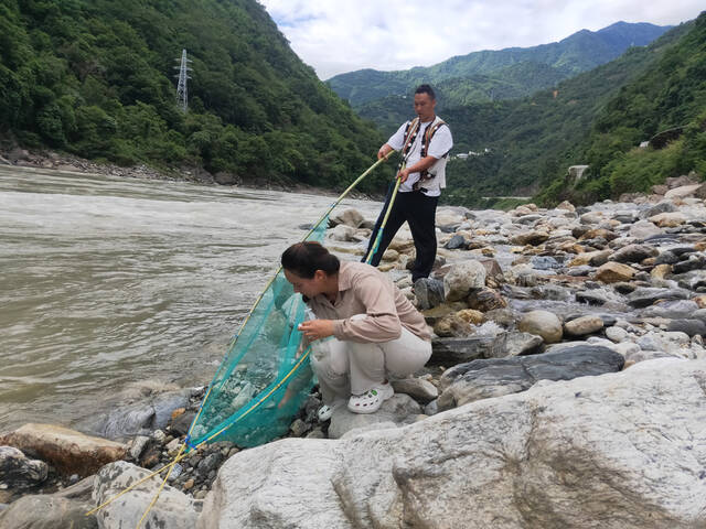 霜晚秋和阿爸在怒江边捕鱼。新京报记者李照摄