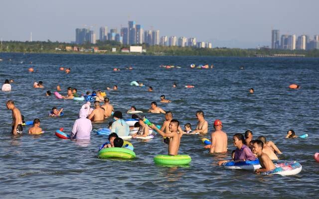 8月9日，湖北襄阳，立秋后连日高温，许多市民来到江边戏水、游泳，享受江水清凉。图/IC photo