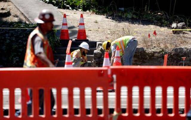 资料图：美国建筑工人们在公路项目上工作。