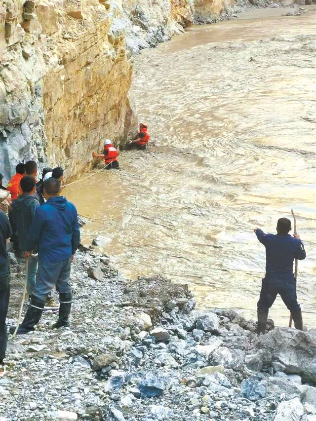 图为民警夏永军、杨洪营救被困群众的现场。(图片来源：人民日报微信公众号)