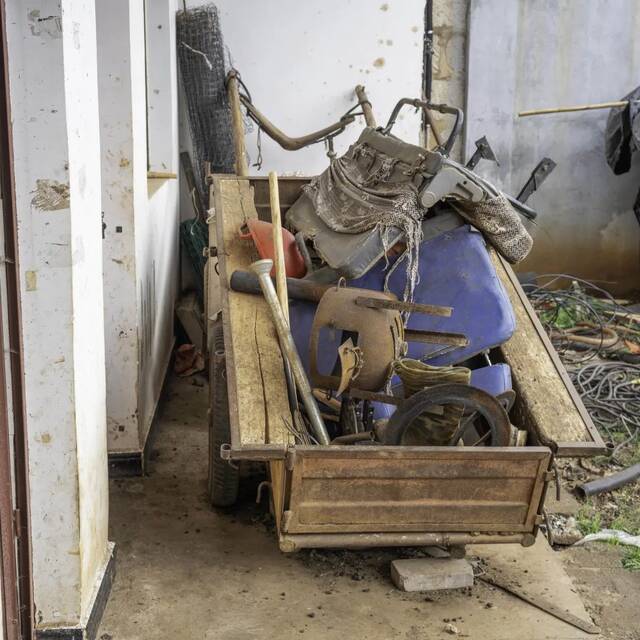 许多破旧的家具堆在了门口废弃的农用车后斗里（金海摄）