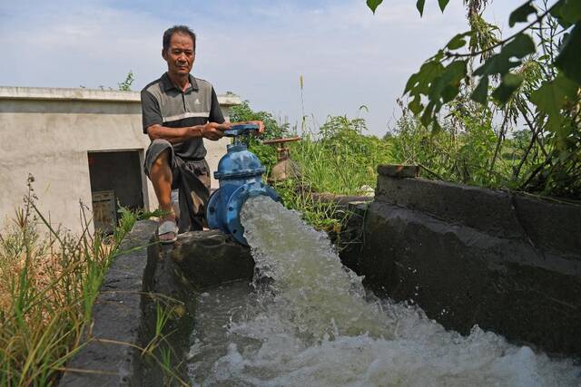 在江西省庐山市沙湖山管理处长湖管理站，农民用水泵抽水灌溉农田。新华社记者万象摄