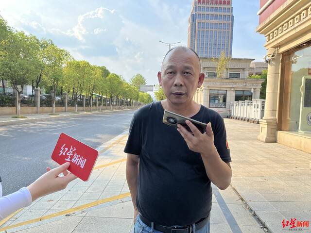 ↑劳声桥17日在江西省高级人民法院外接受红星新闻采访