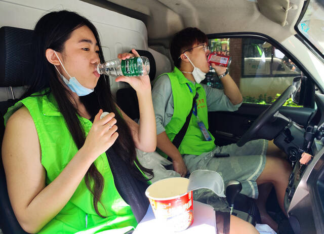 8月14日，张海洋（右）、吴凡力在货车上吃午饭。新华社记者郭程摄