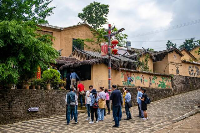 游客在腾冲市清水乡三家村中寨司莫拉佤族村参观。新华社记者陈欣波摄