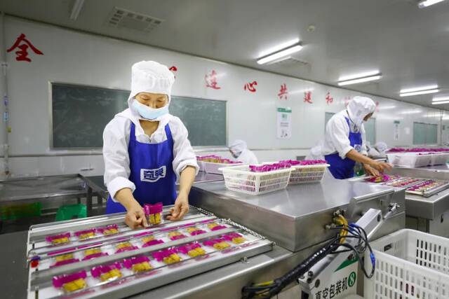 2022年7月5日，重庆市梁平区奇爽食品有限公司，工人在对预制菜产品进行真空包装。图/中新社发刘辉摄