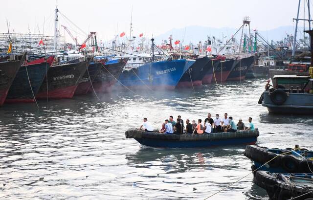 8月24日，在广东阳江市海陵岛闸坡国家级中心渔港，海上从业人员搭乘小艇靠岸。新华社记者邓华摄