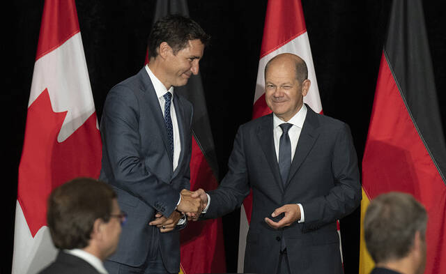 加拿大总理特鲁多和德国总理朔尔茨在举行的签字仪式上握手。
