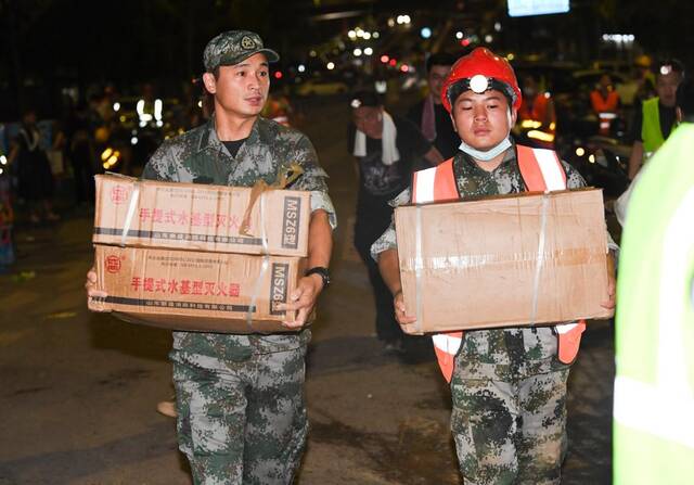 8月26日凌晨，救援人员在搬运灭火器。新华社记者王全超摄
