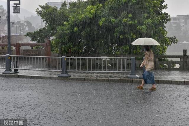 2022年8月25日，四川雅安，高温干旱告一段落，雨城区迎来了一场久违的降雨，市民冒雨出行。视觉中国图