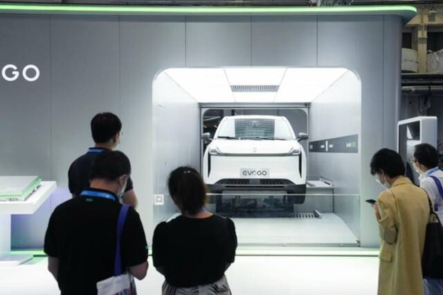 8月26日，2022世界新能源汽车大会上，参观者在观看一辆可换电池新能源汽车的换电演示。新华社记者鞠焕宗摄