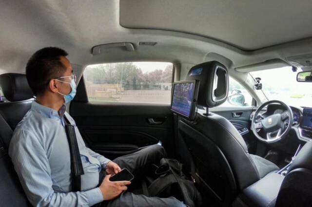 4月25日，在北京经济技术开发区，一名乘客在体验“主驾无人、副驾驶配备安全员”的无人驾驶车。新华社记者彭子洋摄