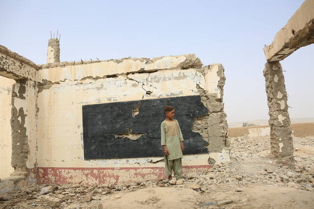 8月23日，在阿富汗南部赫尔曼德省桑金地区，一名男孩站在废墟之中。新华社发（塞夫拉赫曼·萨菲摄）