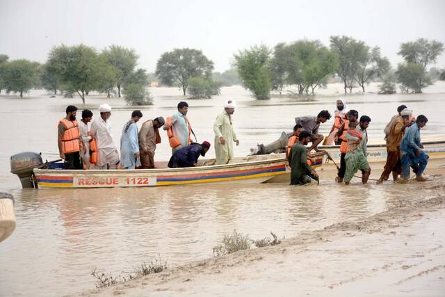 8月27日，在巴基斯坦拉金布尔，救援人员帮助受灾民众撤离。新华社发（曼苏尔摄）