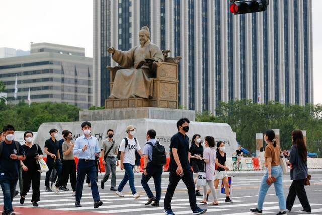 8月3日，行人佩戴口罩在韩国首尔光化门广场过马路。新华社记者王益亮摄