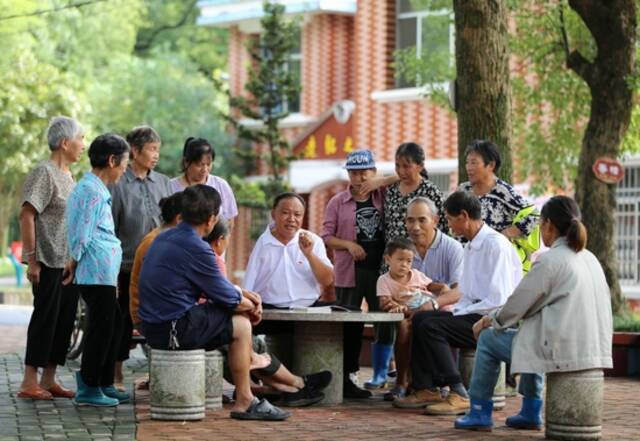 江西芦溪县宣风镇珠亭村人民调解员阳昌绍（中）为珠亭村的百姓宣讲民法典知识（2021年8月17日摄）。新华社记者胡晨欢摄