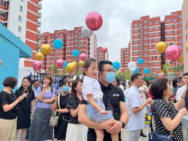 8月28日是幼儿园开放日，快递员王钰君（前排中间）带着女儿王诗雨在幼儿园参观体验。（受访者供图）