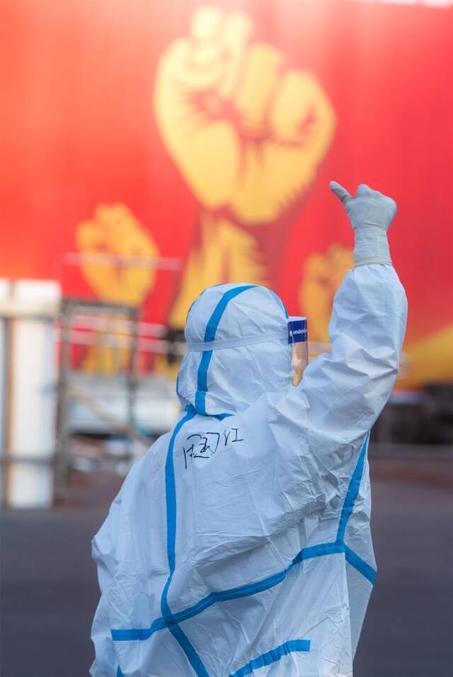 2020年2月12日，安徽援鄂医疗队队员周国红在湖北省武汉体育中心方舱医院前竖起拇指为自己和同伴加油鼓劲。新华社记者肖艺九摄