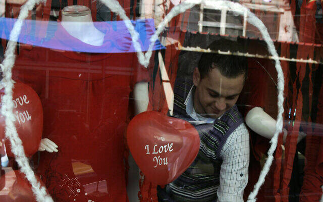 2011年2月14日情人节，巴勒斯坦约旦河西岸城市纳布卢斯，一名商家在其商店中进行节日装扮