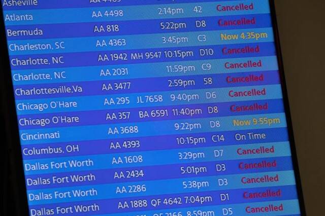 图说:2020年 3月 21日，纽约拉瓜迪亚机场美国航空公司航站楼的到达板显示已取消或延误的航班以及准时的航班。（美联社）