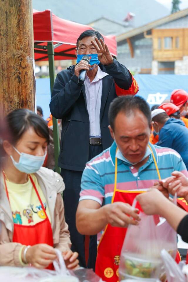 9月7日，志愿者邹银禄站在凳子上维持秩序。（新华社记者沈伯韩摄）