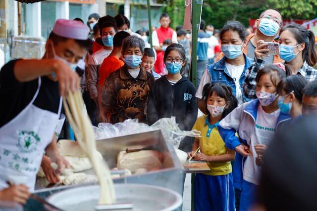 9月7日，牛肉面摊位前，众多群众被香气吸引来驻足等待。（新华社记者沈伯韩摄）