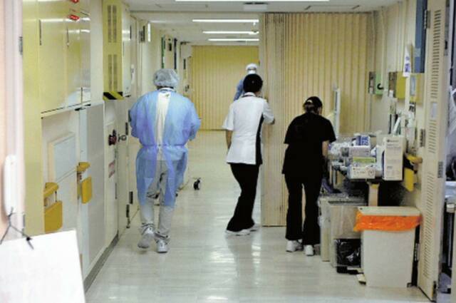 京都医院的医护人员在走廊上匆忙奔波（《读卖新闻》）